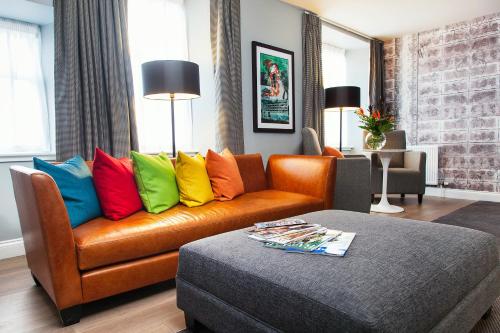 a living room with a couch with colorful pillows at Malmaison Edinburgh in Edinburgh