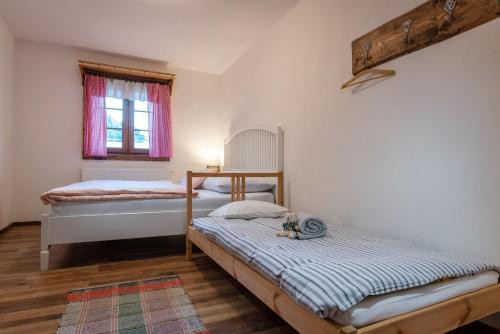 a bedroom with two beds and a window at Chalupa Pri Grúni in Zázrivá