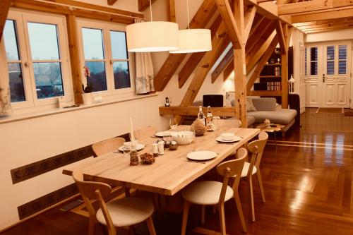 a wooden table and chairs in a room with windows at Zum Alten Backhaus in Burg