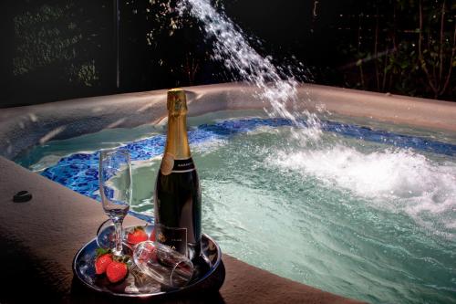 - Uma garrafa de champanhe e um copo numa banheira de hidromassagem; em Villa Evridiki by Pelion Esties em Agios Georgios Nilias