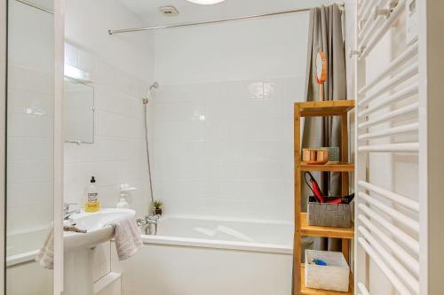 une salle de bain avec une baignoire blanche et un lavabo dans l'établissement Bohemian, à Saint-Malo