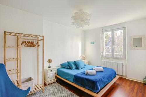 une chambre avec un lit bleu et une fenêtre dans l'établissement Bohemian, à Saint-Malo