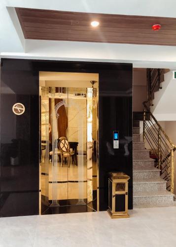 a lobby with a staircase and a glass door at Swan Hotel in Ho Chi Minh City