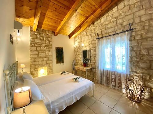 a bedroom with a bed and a stone wall at Eros in Astérion