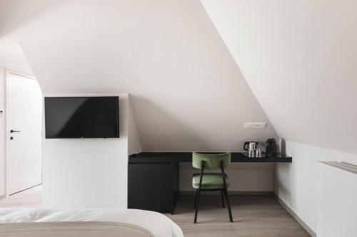 sypialnia z łóżkiem i biurkiem z telewizorem w obiekcie Salons Denotter w mieście Zedelgem