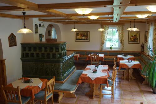 a restaurant with tables and chairs and a stove at Penzion Kaps in Bled