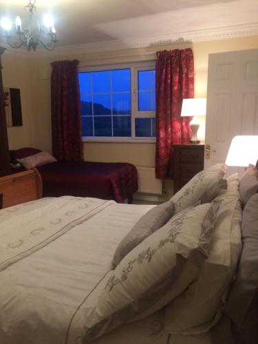 a bedroom with a large bed with a window at Hillcrest farmhouse Bed & Breakfast in Boyhollagh