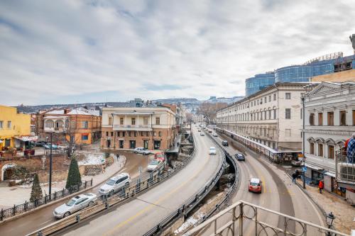 a city street with cars driving down a road at Pushkin 10 Hostel in Tbilisi City
