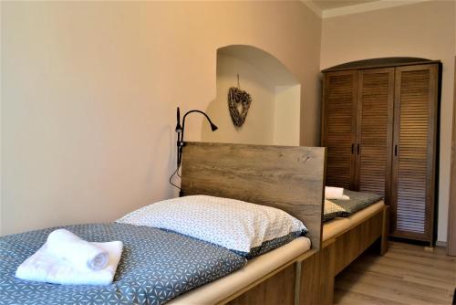 a bedroom with a bed with a wooden headboard at Pension Kotva in Beroun
