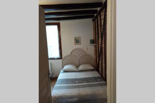 um quarto com uma cama com uma grande cabeceira de cama em Appartement deux pièces - coeur de ville quartier cathédrale em Tours