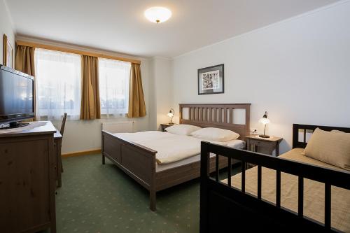 a hotel room with a bed and a television at Penzion Kaps in Bled