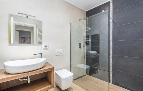 La salle de bains est pourvue d'un lavabo et d'une douche en verre. dans l'établissement Apartments Tizi Rovinj, à Rovinj