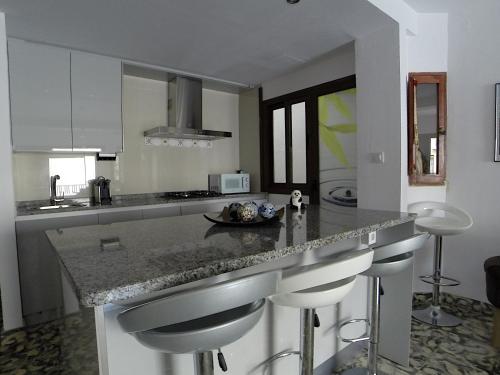 a kitchen with a counter with bar stools at Apartment PaCa Javea in Jávea