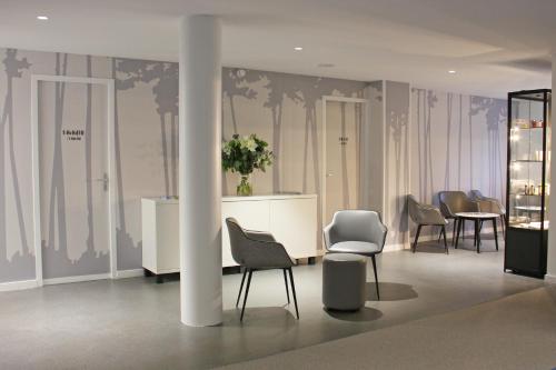 a room with chairs and tables and a column at Hôtel du Parc & Spa in Hossegor