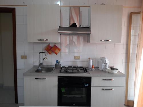 a kitchen with a sink and a stove top oven at casaLiuccia in Mondello