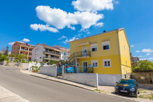 a yellow house on the side of a street at LUKA in Crikvenica
