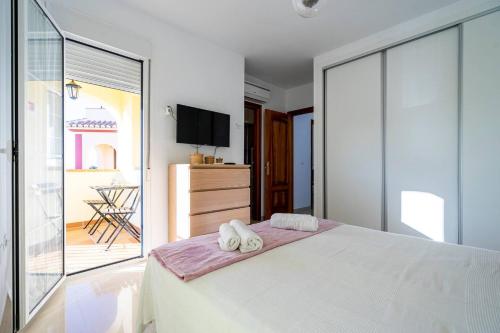 1 dormitorio con 1 cama blanca grande y toallas. en Villa Antonia Mar - Private Pool - Punta Lara Nerja en Nerja