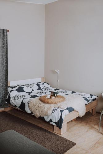 a bedroom with a bed with a black and white comforter at Kevade Guesthouse with Sauna in Kuressaare