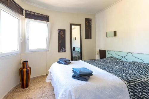 een slaapkamer met een bed met blauwe handdoeken bij Casa Mar y Montaña in Denia