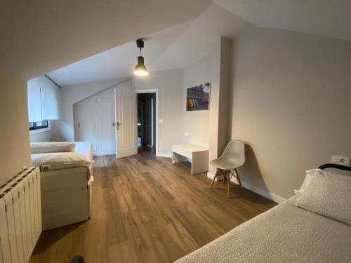 a bedroom with two beds and a table and a chair at Housingcoruña playa miño 5 in Miño