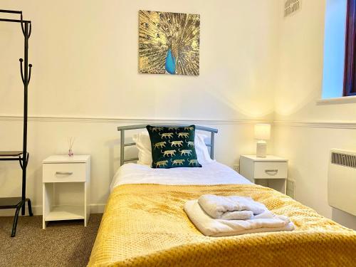 a bedroom with a bed with towels on it at EasyRest Spalding - 4 Beds & Free Parking - Central & Modern Open Plan Apartment - Convenient Location in Spalding