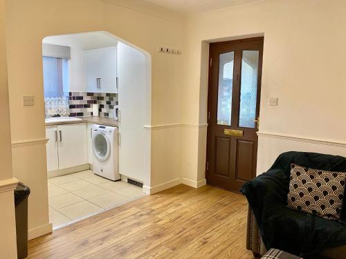 a living room with a couch and a kitchen at EasyRest Spalding - 4 Beds & Free Parking - Central & Modern Open Plan Apartment - Convenient Location in Spalding