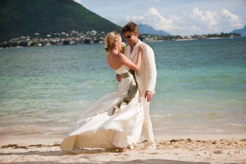 a bride and groom standing on the beach at Sands Suites Resort & Spa in Flic-en-Flac