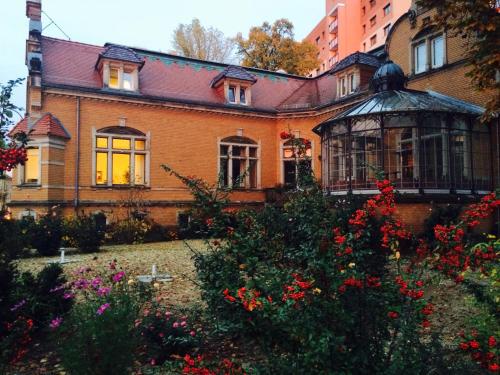 een oud huis met een tuin ervoor bij Pension Sanssouci in Potsdam