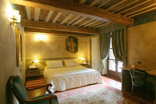 a bedroom with a bed and a desk and a chair at Relais Mont Blanc Hotel & Spa in La Salle