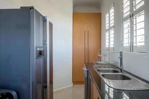 uma cozinha com 2 lavatórios e um frigorífico em Villa Royale em St Helena Bay