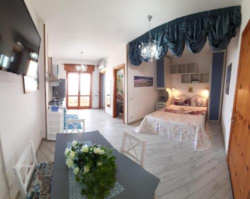 um quarto com uma cama e uma mesa com flores em Bilocale Punta Rosa - Fronte Spiaggia em Otranto