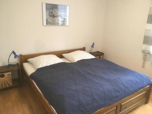 a bed with a blue comforter in a bedroom at Ferienwohnung Kastanienblick oder Parkblick in Ziethen