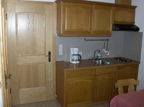 a kitchen with wooden cabinets and a blender on a counter at Haus Moosbach in Oberwössen