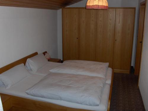 a small bedroom with a bed with white sheets at Haus Moosbach in Oberwössen