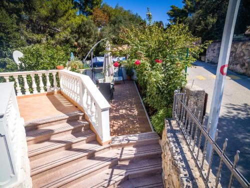 a wooden staircase leading to a house with flowers at Apartment Siesta in Cavtat