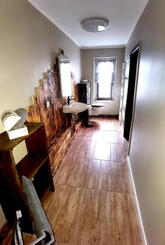 a living room with a wooden floor and a staircase at Apart Oderblick in Neubleyen