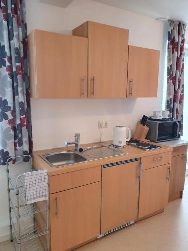 a kitchen with a sink and a microwave at Gästehaus Altstadttraum in Leer