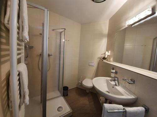 a bathroom with a sink and a shower and a toilet at Gästehaus Altstadttraum in Leer