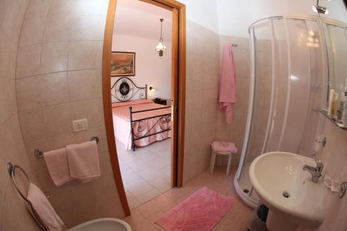 a bathroom with a shower and a sink and a bed at Hotel Lo Scirocco in Campo nell'Elba
