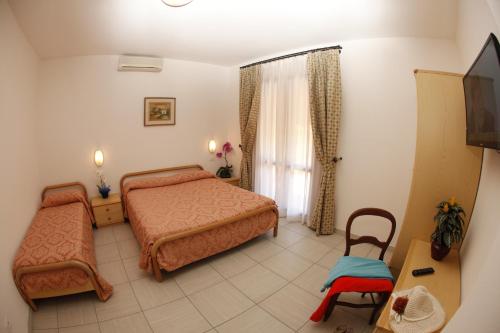 En eller flere senger på et rom på Hotel Lo Scirocco