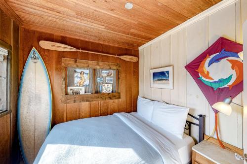 a bedroom with a surfboard and a bed with a kite at Cottage by the Sea (MCA #1213) in Manzanita