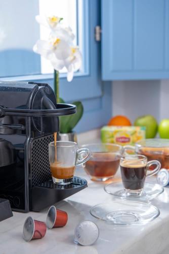 a kitchen counter with three cups of coffee on plates at Sole d'oro Luxury Suites in Oia