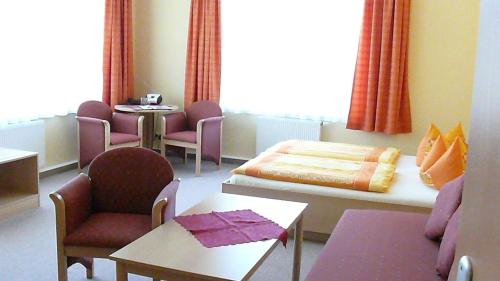 a hospital room with a bed and a table and chairs at Pension Kreisel in Bad Kösen