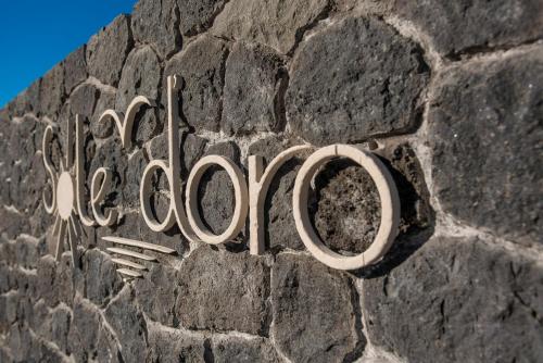 a metal sign on a stone wall at Sole d'oro Luxury Suites in Oia