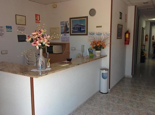 a room with a counter with flowers on it at Pensión Egea II in Puerto de Mazarrón