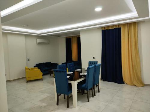 a dining room with a table and blue chairs at Ramco For Furnished Apartments And Accommodation Compound Leila in Cairo
