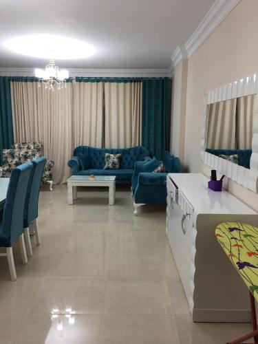 a living room with a blue couch and a table at Ramco For Furnished Apartments And Accommodation Compound Leila in Cairo