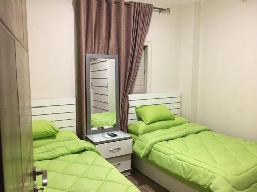 a bedroom with two beds and a mirror at Ramco For Furnished Apartments And Accommodation Compound Leila in Cairo