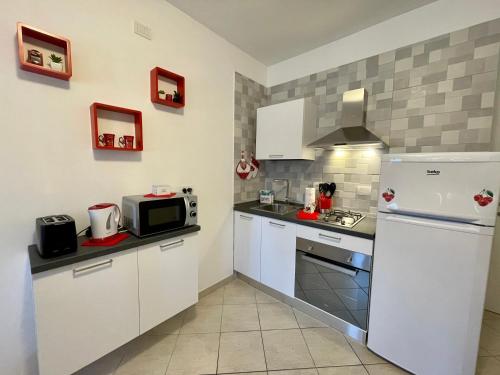 a kitchen with a refrigerator and a microwave at Perla d'aMare Rubino - Appartamento sul mare in San Benedetto del Tronto