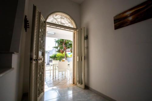 an open door leading to a patio with a table at Villetta Emma in Torre Lapillo